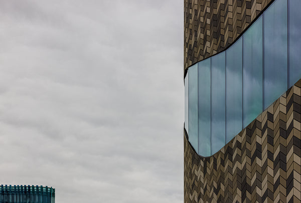 Fine art architecture photography print of geometric chevron building facade and reflective glass against a cloudy sky in Christchurch New Zealand