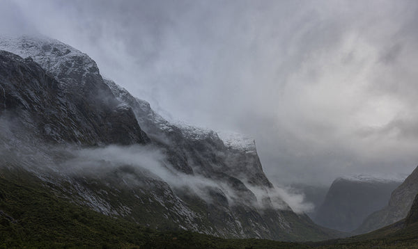 Fine art photography print of misty snow-capped mountains and dramatic clouds at Milford Sound Fiordland New Zealand