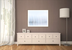 Echoes of Light, abstract Intentional Camera Movement fine art print, pale blue and white tones with soft vertical streaks, framed in a dark timber frame in a room mockup