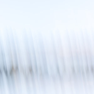 Minimalist abstract fine art photography print of soft diagonal light streaks in pale blue and white tones