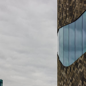 Fine art architecture photography print of geometric chevron building facade and reflective glass against a cloudy sky in Christchurch New Zealand