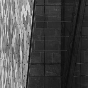 Black and white fine art photography print of geometric chevron tile facade contrasting with dark reflective glass in Christchurch New Zealand