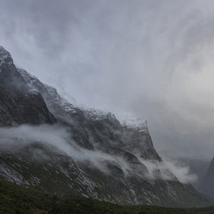 Fine art photography print of misty snow-capped mountains and dramatic clouds at Milford Sound Fiordland New Zealand