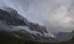 Fine art photography print of misty snow-capped mountains and dramatic clouds at Milford Sound Fiordland New Zealand